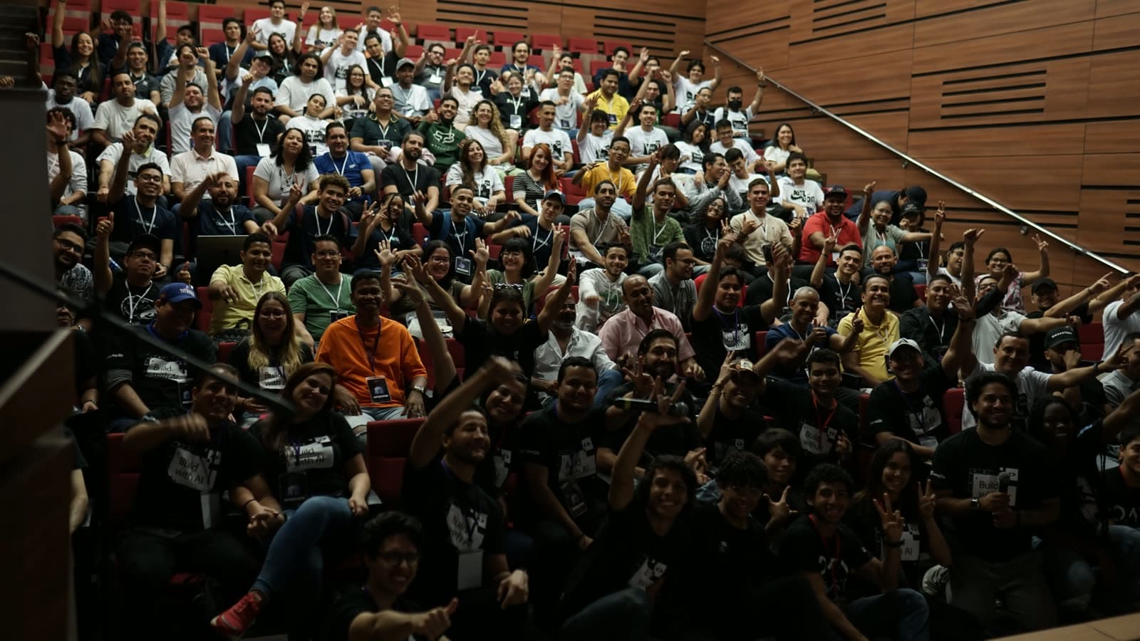 Auditorio lleno de participantes celebrando con los brazos en alto en la apertura de Barranqui-IA 2024